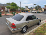 Well-maintained Mercedes-Benz C280 parked on a residential street, showcasing a clean exterior and original leather interior.