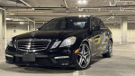 2010 Mercedes-Benz E63 AMG parked indoors, showcasing its sleek black design and sporty exterior features.