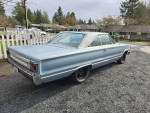 1967 Plymouth Satellite in light blue, parked in a driveway, showcasing rear view and original design features.