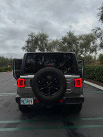 Rear view of a 2019 Jeep Wrangler Sport 4WD parked, showcasing its design and features.