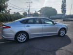 2014 Ford Fusion SE in silver color parked on the street, featuring alloy wheels and clean exterior.