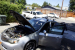 2008 Subaru Impreza WRX AWD with open hood, showcasing engine condition, parked on the street.