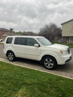 2014 Honda Pilot EX FWD parked on the street, featuring leather interior and new tires, ideal for family travel.