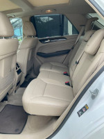 Interior view of a 2015 Mercedes ML350 showing comfortable beige leather rear seats and spacious layout.