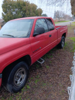 1998 red Dodge Ram truck parked on grass, showing minor dents and new steering box.