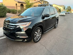 2017 Honda Pilot Elite AWD parked on street, featuring dark tint and excellent exterior condition.