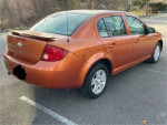 2005 Chevrolet Cobalt LS in orange color with sunroof and alloy wheels parked on the street