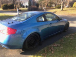 2003 Infiniti G35 Coupe in blue parked on the street, showcasing its sleek design and rear wheel drive features.