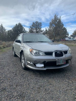 Well-maintained Subaru Impreza with body damage, suitable for repair or parts, located outdoors