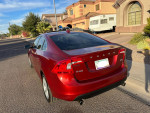 Red 2013 Volvo S60 T5 parked on street, showcasing sleek design and rear view.