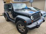 2010 Jeep Wrangler Mountain Edition parked outside, showing its clean title and manual transmission, in good condition.