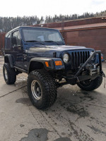 2000 Jeep Wrangler Sport 4WD with new tires and upgraded features parked outdoors