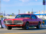 Stunning 1968 Mercury Cougar parked on a street with a vibrant urban backdrop
