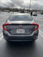 Rear view of a 2016 Honda Civic EX sedan parked in a lot, showcasing clean design and tinted windows.
