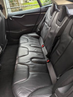Interior view of the back seats in a 2014 Tesla Model S 85, featuring black leather upholstery.