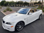 2012 BMW M3 convertible in white parked, showcasing stylish design and luxury features.