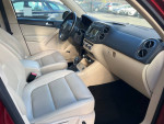 Interior of a 2014 Volkswagen Tiguan SEL, featuring beige leather seats and modern dashboard controls.