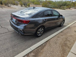 2021 Kia Forte LXS sedan in gray color, parked on Tucson street, showcasing sleek design and exterior features.