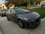 2018 Hyundai Elantra GT hatchback in gray parked on driveway, featuring alloy wheels and rear camera.
