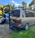 1994 Toyota Hiace SuperCustom van with a bicycle rack, parked in green surroundings