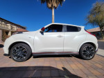 Side view of a clean 2015 Nissan Juke Nismo with 109,000 miles, parked in a sunny driveway.