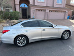 2014 Infiniti Q50 Premium sedan in silver parked outside a modern home with excellent smooth drive and sporty options.