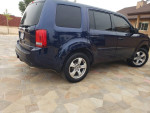 2014 Honda Pilot EX in good condition, blue exterior, parked on stone pavement, showing back view.