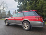 1999 Subaru Outback wagon in red, showcasing leather interior, all-wheel drive, and double sunroofs.