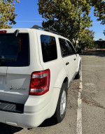2012 Ford Escape Hybrid parked, showcasing its design and low mileage in a sunny outdoor setting.