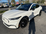 White Ford Mustang Mach-E Premium with black rims parked outdoors in pristine condition