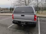 Rear view of a 2015 Toyota Tundra SR 4WD parked, featuring a Leer Canopy and Yakima roof rack.