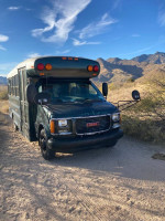 2002 Chevy Bluebird school bus conversion parked in a desert landscape, ready for next adventure.