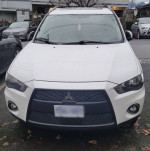 Front view of a 2010 Mitsubishi Outlander, white color, with new winter tires ready for sale.