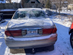 2000 Buick LeSabre parked in snow, showing rear view with license plate and winter conditions.