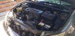 Engine of a 2005 Toyota Camry with low mileage, showing good condition and minor cosmetic dent.