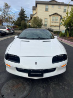 Front view of a pristine 1997 Chevrolet Camaro Z28 in white, showcasing its sleek design and classic appeal.