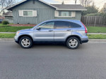 2011 Honda CR-V EX-L FWD, blue SUV parked on the street, showcasing its sleek design and spaciousness.