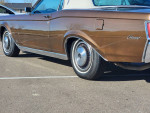 1970 Lincoln Continental Mark III in brown with white convertible top, showcasing classic design and tire details.