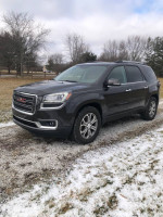 2014 GMC Acadia AWD parked in snowy landscape, featuring leather interior and sunroof, for sale with 127,000 miles.