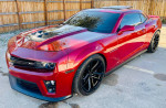 2013 Chevrolet Camaro ZL1 in red, showcasing front view with sleek design and enhanced wheels.