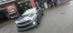 2010 Chevrolet Camaro LS with custom racing features and low mileage parked outside a tire shop