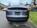 Rear view of a 2023 Tesla Model Y Long Range parked on a residential street