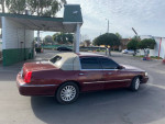 Red Lincoln Towncar parked at a car wash, showcasing its clean exterior and well-maintained condition.