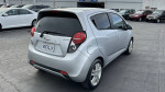 2013 Chevrolet Spark in silver, showcasing rear view with clean design, parked among other vehicles.