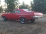 1972 Chevrolet Nova in red parked on dirt, featuring custom dual exhaust and high compression engine.