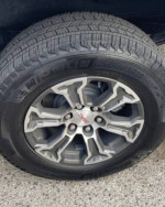 Close-up of a Michelin tire on a 2022 GMC 1500 Sierra truck, showcasing modern tread design and alloy wheel.