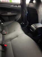 Interior view of a 2012 Subaru Impreza WRX with black leather upholstery and spacious seating.