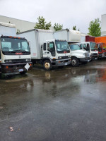 Several GMC T7500 and T8500 trucks parked, showcasing their 26FT and 30FT boxes in good condition.