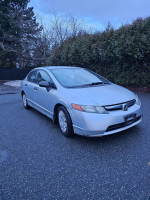 2006 Honda Civic in mint condition, low mileage, silver exterior, parked on a driveway with trees in the background