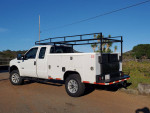 2006 Ford F250 Turbo Diesel 4x4 utility work truck with custom rims and new tires parked outdoors